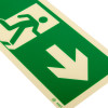 Close up of fire exit sign rigid plastic showing green figure walking through door and arrow pointing right