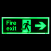 fire exit sign rigid plastic right size t showing green illuminated running figure and right arrow in dark background