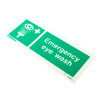 Green emergency eye wash sign shown at an angled view with white text and symbols on a green background