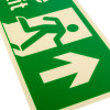 Close up of a fire exit sign rigid plastic up size j showing a green running figure and arrow on a white background