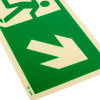 Close up of fire exit sign rigid plastic up right size k showing an arrow pointing downwards on a green background