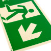 Close up of fire exit sign rigid plastic down right size j showing white running figure with arrow on green background