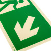 Close up of a fire exit sign rigid plastic down right size k showing a white downward arrow on a green background