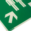 Close up of assembly point sign rigid plastic showing white arrow and figures on green background