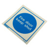angled view of a fire door keep shut sign made of rigid plastic showing bold white text on a blue circle background