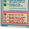 Closeup of fire action sign with safety instructions in red and blue text on white background