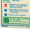 Closeup of fire action sign showing instructions and symbols for safety and contacting a fire warden