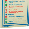Closeup of fire action sign showing instructions and symbols in red, blue, green, and black text on white background