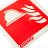 Close up of fire equipment location id sign showing a white helmet and fire flames on a red background