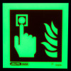 Square fire alarm id sign glowing green in the dark showing a hand pressing a button next to flames
