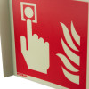 Closeup of a jalite panoramic fire alarm location no text sign showing a hand pressing a button with flame symbols on red background