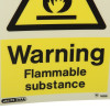 Closeup of a warning flammable substance sign with black text on a yellow background showing a fire symbol