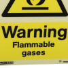 Closeup of a warning flammable gases sign showing the words warning flammable gases on a yellow background