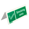 Angled view of a designaated smoking area table top sign with white text and icon on a green background