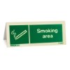 Angled view of a designated smoking area table top sign with a smoking symbol and text on a green background