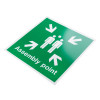 angled white rigid plastic assembly point sign showing two people and arrows pointing inward with text assembly point