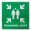 white rigid plastic assembly point sign with two people and arrows pointing inwards with assembly point text visible front view