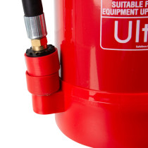 Close‑up of a red fire extinguisher showing the hose connection, brass fitting, and part of the product label.