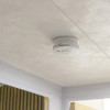 Kidde 10Y29 10 Year Optical Smoke Alarm installed on a white textured ceiling in situ