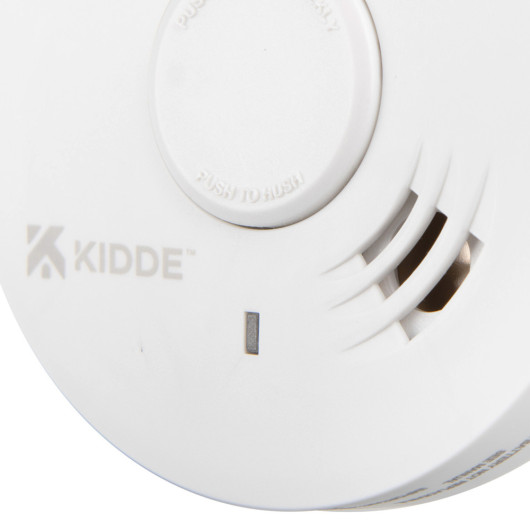 Closeup detail of the Kidde 10yr battery optical smoke alarm showing the test button and vents