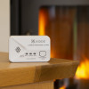 Kidde 2030-DCR Carbon Monoxide Alarm on a wooden table with a fireplace burning in the background