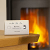Kidde K10LLCO 10 Year Carbon Monoxide Alarm on a wooden table with a fireplace burning in the background