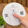 kidde 10sco combination smoke and co alarm held in hand with plant in background