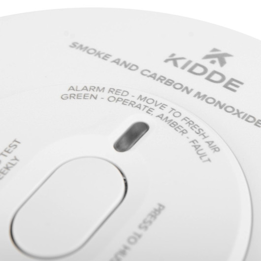 Closeup of the button on a Kidde combination smoke carbon monoxide alarm with text and vents visible