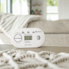 Kidde K5DCO Digital Carbon Monoxide Alarm on a table with a beige sofa and blanket in the background