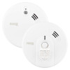 Two round white Kidde FireX alarms shown front‑on, one smoke alarm and one heat alarm, each with ventilation slots and central test buttons.