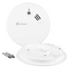 A Kidde smoke alarm shown beside its mounting base, screws and wall plugs, highlighting the installation components.