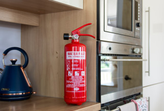 A red fire extinguisher next to a blue kettle