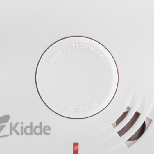 Close-up of the Kidde Ke10Y29 Test Button on a white device with Push to Test Weekly and Push to Hush text visible