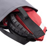 Promove adult sling folded and partially inside a grey carrying bag with visible straps and black padding