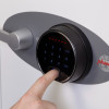 Close up of a finger pressing the fingerprint lock on a phoenix titan 1281 safe