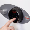 Finger pressing a button on the black circular keypad of the phoenix titan 1283 fingerprint lock in use