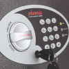 Front close up of phoenix vela security safe deposit slot electronic lock keypad with key inserted in lock