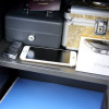 Contents inside a safe with a phoenix vela security electronic lock showing passport phone keys and a small box on shelves