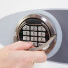 Close-up of a hand using the handle on the phoenix fortress 1181 security safe electronic lock keypad