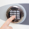 Finger pressing keypad on phoenix fortress 1181 security safe electronic lock keypad in use
