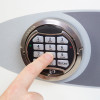 Finger pressing number 5 on the keypad of the phoenix fortress 1183 security safe electronic lock