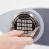 Hand using the handle on the phoenix fortress 1184 security safe electronic lock keypad panel