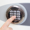 A finger pressing a number on the keypad of the phoenix fortress 1184 security safe electronic lock