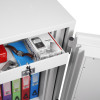 Open drawer of a phoenix firefox fireproof safe electronic lock showing contents including a watch, phone box, camera, and files