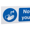 Close up detail of mandatory bathroom hygiene now wash your hands sign showing hand and tap symbol with water droplets