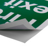 fire exit sign eec directive self adhesive down right sign partially peeled showing sticky backing