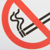 Closeup of no smoking self adheseive vinyl sign showing a cigarette with a red prohibition circle and line