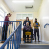 Trainer demonstrating evacuation chair operator training with a person seated in the chair on a staircase