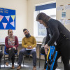 Person demonstrating evacuation chair operator training while others watch in classroom setting with instructor
