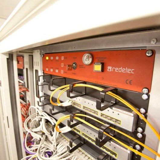 Close up of redetec rack mount fire supression unit installed in a server rack with cables connected